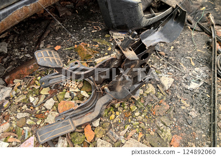 Abandoned car parts lie among the rubble in a forgotten automotive graveyard Abandoned car parts lie among the rubble in a forgotten automotive graveyard 124892060