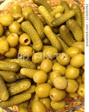 Green olives and pickles displayed together in a vibrant array of textures 124892062