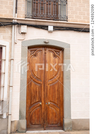 Elegant wooden door with stone frame on classic european building 124892090
