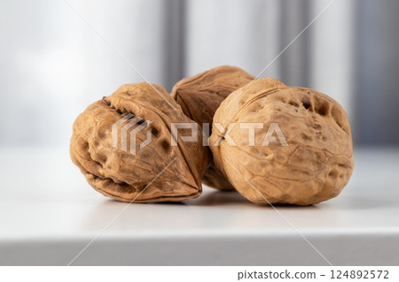 The walnut is a whole textured front view on a gray background with space for text. The walnut is a whole textured front view on a gray background with space for text. 124892572