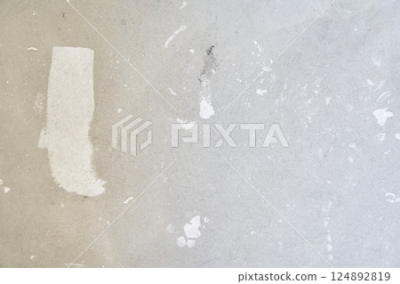 A gray concrete wall with white patches of putty. Uneven wall surface with space for copying. High quality photo 124892819