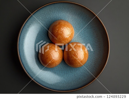 Three round pastries on a blue plate served in an elegant arrangement Three round pastries on a blue plate served in an elegant arrangement 124893229