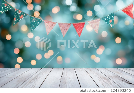 Colorful bunting and flowers decorate a wooden table in a vibrant outdoor setting 124893240