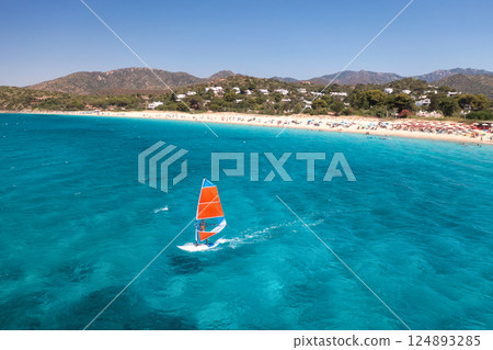 Aerial view of windsurfer on blue sea at sunny summer day Aerial view of windsurfer on blue sea at sunny summer day 124893285