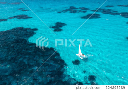 Aerial view of sailboat on blue sea on summer sunny day. Travel Aerial view of sailboat on blue sea on summer sunny day. Travel 124893289