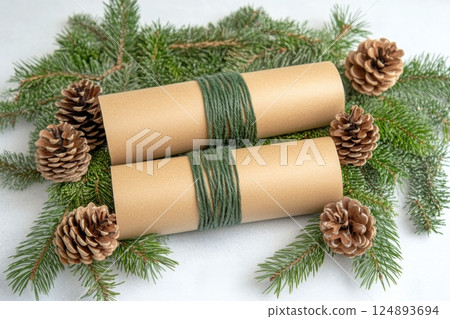 Beautifully wrapped gift with pine sprig and pine cones on marble surface 124893694