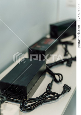 Electric motorcycle charging power supply. Portable charger for charging batteries in a scooter 124894288