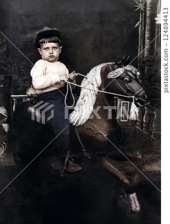 Vintage portrait of a little boy riding a wooden horse. Retro photo from 1940. 124894413