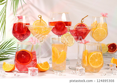 Banner with various glasses of alcoholic drinks and tropical fruits. Cocktails from fruits, ice cubes, rum and tequila. Summer party and relaxation concept. Menu for a bar or cafe 124895308