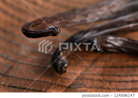 Bourbon Vanilla pods on wooden table, closeup detail on beans tips 124896147