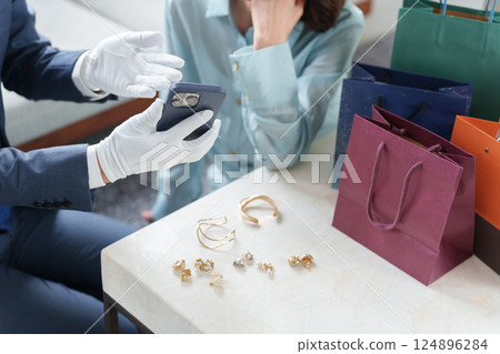 一位流動二手買家與一位女性顧客一起評估商品 124896284