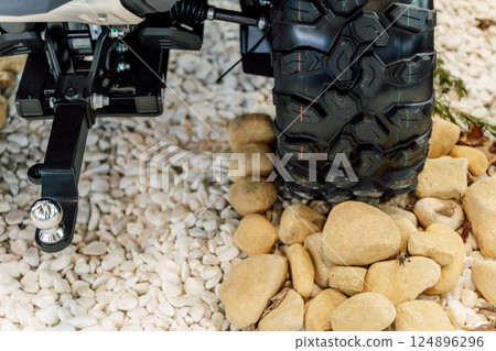 off-road quad bike wheel on a pile of rocks. off-road studded tire on mountain boulders off-road quad bike wheel on a pile of rocks. off-road studded tire on mountain boulders 124896296