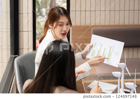 Analysis and Strategy. A woman presenting graphs related to sustainability to a client. 124897148