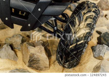 off-road quad bike wheel on a pile of rocks. off-road studded tire on mountain boulders 124897243
