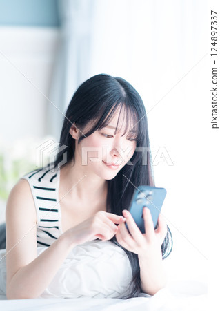 一位獨居的年輕女子在明亮的房間裡上網 124897337