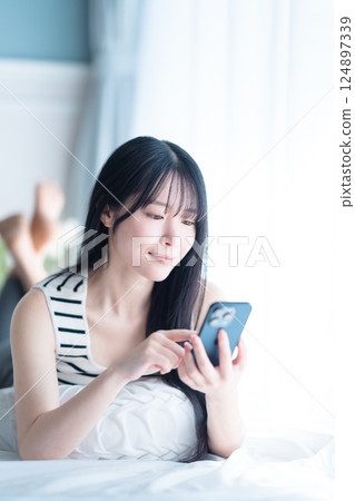 A young woman living alone searching the Internet in a bright room A young woman living alone searching the Internet in a bright room 124897339