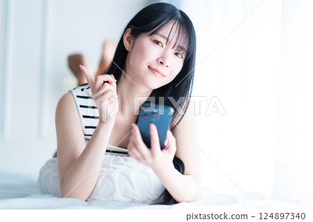 A young woman living alone searching the Internet in a bright room 124897340