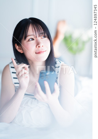 一位獨居的年輕女子在明亮的房間裡上網 一位獨居的年輕女子在明亮的房間裡上網 124897345