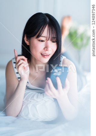 A young woman living alone searching the Internet in a bright room 124897346