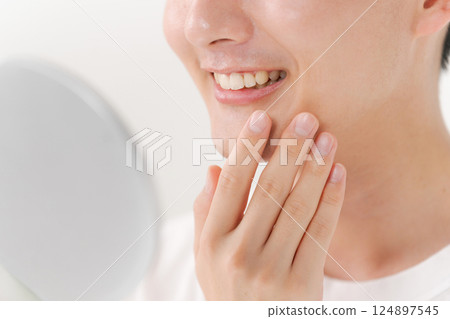 Man looking in a hand mirror Man looking in a hand mirror 124897545