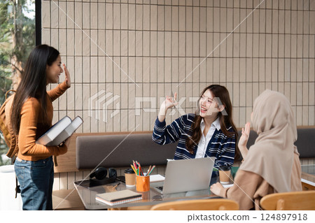 Greetings and Networking. Students exchanging greetings in a friendly study environment at a cafe. Greetings and Networking. Students exchanging greetings in a friendly study environment at a cafe. 124897918