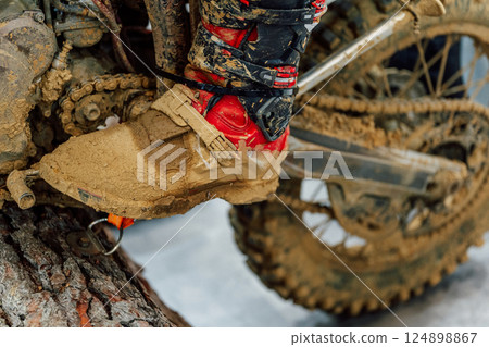 dirty motorcyclist shoes after mountain racing. motorcycle boots in clay after training dirty motorcyclist shoes after mountain racing. motorcycle boots in clay after training 124898867