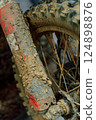 dirty off-road enduro motorcycle wheel. dirt motorcycle tire from off-road racing 124898876