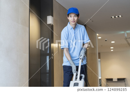 男性清潔人員與商用地毯吸塵器一起工作 124899285