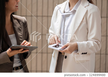 Innovation and Sustainability. Professionals presenting renewable energy concepts in a business setting. Innovation and Sustainability. Professionals presenting renewable energy concepts in a business setting. 124899480