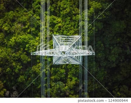 Aerial view of high voltage electric tower in forest 124900944