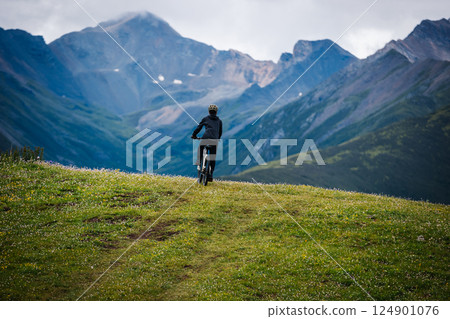 Riding mountain bike on grassland mountain top 124901076