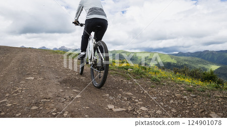 Riding mountain bike on grassland mountain top 124901078