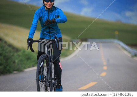 Riding bike on grassland mountain top trail 124901393