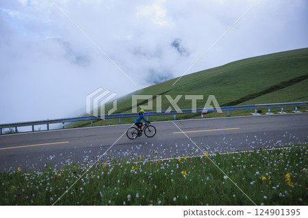 Riding mountain bike on grassland mountain trail 124901395