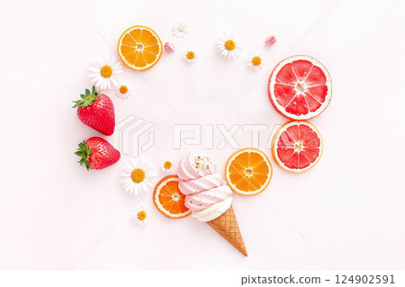 A pink ice cream cone with fresh strawberries, oranges, and grapefruits around it on white background. White flowers make the image feel happy, sweet, and fresh. A pink ice cream cone with fresh strawberries, oranges, and grapefruits around it on white background. White flowers make the image feel happy, sweet, and fresh. 124902591