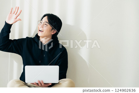 Man using a computer by the wall Man using a computer by the wall 124902636