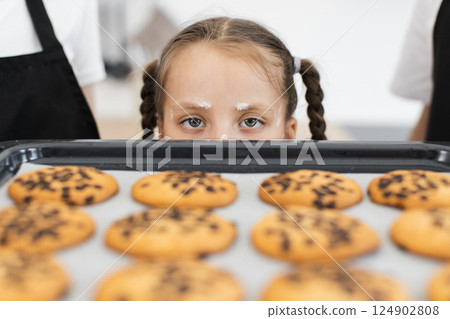 Caucasian children baking cookies together in home kitchen environment, seen preparing and smiling. Caucasian children baking cookies together in home kitchen environment, seen preparing and smiling. 124902808