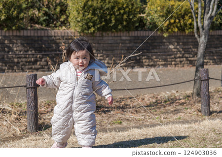 [A one-year-old child playing on the grass at Sagamihara Municipal Asamizo Park] 124903036