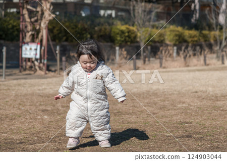 [A one-year-old child playing on the grass at Sagamihara Municipal Asamizo Park] 124903044