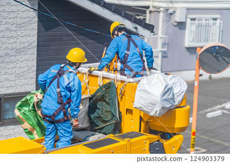 A maintenance worker prepares a work platform to remove a crow's nest from a utility pole. A maintenance worker prepares a work platform to remove a crow's nest from a utility pole. 124903379