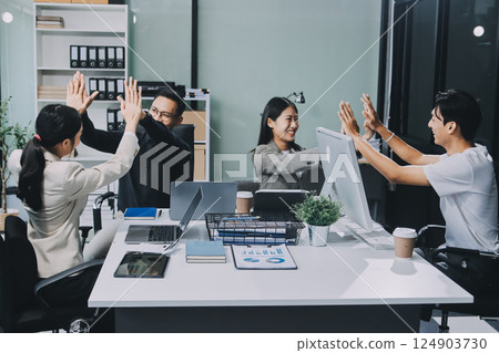 Cheerful meeting room, businesspeople celebrate with handshaking. Successful project was completed before the deadline. Business partnership and collaboration in project management. Habiliment 124903730