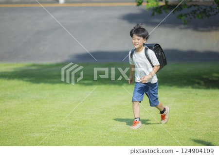 Elementary school student carrying a backpack walking outdoors 124904109