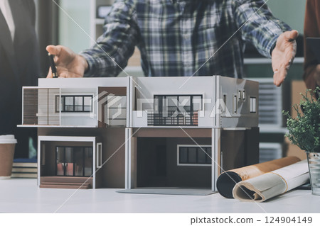 Construction, planning and architects meeting about design of building, strategy and working in industrial collaboration. Architecture workers talking about maintenance project with paper and a model Construction, planning and architects meeting about design of building, strategy and working in industrial collaboration. Architecture workers talking about maintenance project with paper and a model 124904149