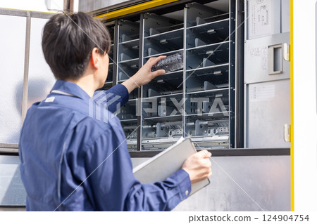 一名男子正在為自動販賣機加料 一名男子正在為自動販賣機加料 124904754