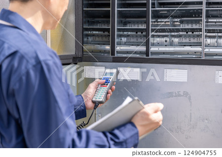 一名男子正在為自動販賣機加料 124904755