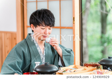 年輕的亞洲男子在日式旅館享用懷石料理(客房服務、懷石料理、禦膳、奢華) 年輕的亞洲男子在日式旅館享用懷石料理(客房服務、懷石料理、禦膳、奢華) 124904929