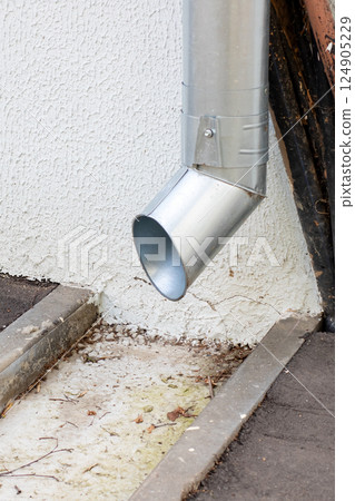 A durable metal pipe is securely attached to the side of a building 124905229