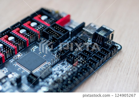 This is a closeup view of a motherboard resting on a wooden table This is a closeup view of a motherboard resting on a wooden table 124905267