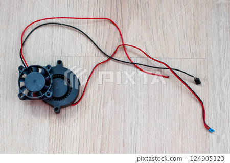 There exists a small fan that has red and black wires connected to it There exists a small fan that has red and black wires connected to it 124905323