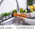 Woman hands washing fresh carrots in the kitchen 124905635